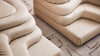 Beiges Ledersofa von Desede Switzerland mit geschwungenem Design auf Teppich.