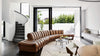 Braunes Ledersofa von Desede Switzerland in elegantem Wohnzimmer mit großen Fenstern.