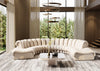 Rundes, sandfarbenes Ledersofa von Desede Switzerland im eleganten Design vor großen Fenstern.