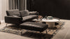 Schwarzes Ledersofa mit Hocker von Desede Switzerland auf gemustertem Teppich im Wohnzimmer.