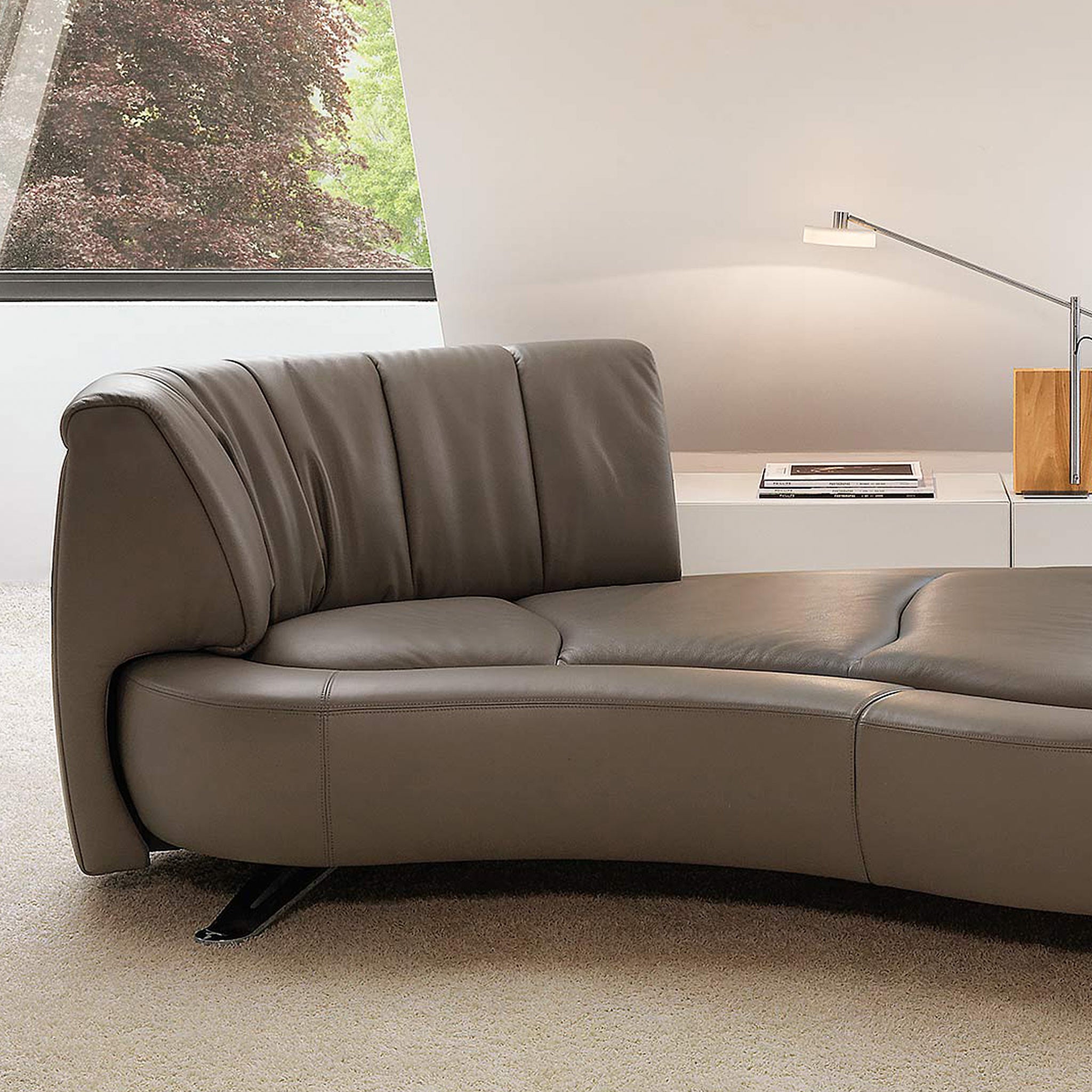 Braunes Ledersofa von Desede Switzerland mit geschwungener Form und gepolsterter Rückenlehne.