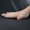 Eine Hand berührt schwarzes Leder von Desede Switzerland, betont Nachhaltigkeit und Qualität.