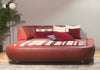Rotes Lederbett von Desede Switzerland mit dekorativen Kissen und gemütlicher Liegefläche.