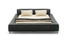 Schwarzes Lederbett von Desede Switzerland mit gepolstertem Kopfteil und eleganten Metallfüßen.