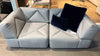Graues Ledersofa von Desede Switzerland mit geometrischem Design und blauen Kissen.
